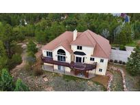 Stunning aerial view of home featuring a brown roof, stucco exterior, and a spacious deck at 1120 Brenthaven Ct, Monument, CO 80132