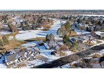An aerial view of a snow-covered landscape shows the home and surrounding neighborhood in winter at 78 Fairway Ln, Littleton, CO 80123