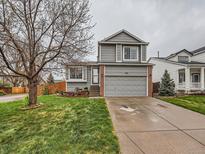 Charming gray two-story home with a well-manicured lawn, brick accents, and attached two-car garage at 378 Benton St, Castle Rock, CO 80104