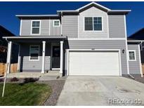 Charming two-story home with gray siding and a two-car garage, plus landscaped front yard at 2351 Monte Vista St, Fort Lupton, CO 80621