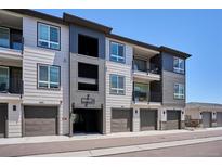 Modern townhome featuring a gray exterior with garage and balcony at 16860 Askins Loop # 102, Parker, CO 80134