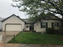 Ranch-style home with attached garage and well-maintained lawn at 16094 E Exposition Dr, Aurora, CO 80017