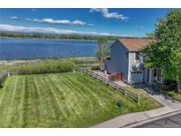 Charming home with a large, well-manicured lawn and stunning lake views at 1353 Mallard Ln, Brighton, CO 80601