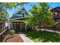 Charming home with a well-manicured lawn, mature tree, and inviting front porch at 1612 S Logan St, Denver, CO 80210