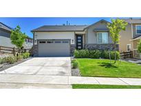 Charming single-Gathering home features a two-car garage, stone accents, and a well-manicured lawn at 4040 Eaton Park St, Aurora, CO 80019