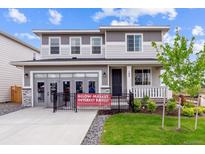 Charming two-story home with gray siding, a welcoming front porch, and a well-maintained lawn at 104 Wooten Ave, Brighton, CO 80601