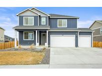 Charming two-story home with a three car garage and manicured front yard at 562 Twilight Ct, Fort Lupton, CO 80621