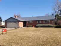 Charming brick home with a well-maintained lawn and mature landscaping at 5922 S Otis Ct, Littleton, CO 80123