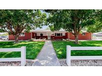 Charming brick home featuring a lush, green lawn and mature trees at 11542 W 29Th Pl, Lakewood, CO 80215