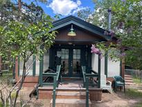 Charming cabin with a cozy front porch, perfect for relaxing and enjoying the surrounding nature at 4393 Pima Rd, Indian Hills, CO 80454