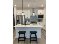 Modern kitchen features a center island, stainless steel appliances, and stylish backsplash at 348 N. Geneva St, Aurora, CO 80010
