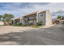 View of gray condo building with stairs leading to 2nd story entrance at 7165 S Gaylord St # E07, Centennial, CO 80122