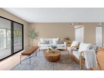 Bright living room featuring a modern design, balcony access, and neutral color palette at 921 S Walden Street # 205, Aurora, CO 80017