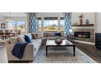 Inviting living room with a fireplace, a large sectional sofa, and bright natural light at 3093 Belay Pt, Castle Rock, CO 80108