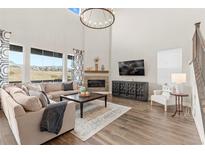 Spacious living room featuring a cozy fireplace and large windows at 3093 Belay Pt, Castle Rock, CO 80108