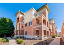 Attractive three-story townhome with brick and stucco exterior, private balconies, and landscaped walkway at 4100 Albion St # 307, Denver, CO 80216