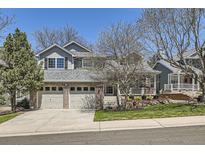 Charming two-story home with a well-manicured lawn, brick accents, and a two-car garage at 9916 Spring Hill Ln, Highlands Ranch, CO 80129