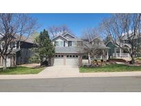 Charming two-story home with a brick facade, well-maintained lawn, and a two-car garage at 9916 Spring Hill Ln, Highlands Ranch, CO 80129
