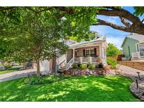 Charming home featuring a well-maintained lawn, mature trees, and a welcoming front porch at 9916 Spring Hill Ln, Highlands Ranch, CO 80129