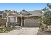Charming two-story home with stone accents, a well-maintained lawn, and a convenient attached two-car garage at 4625 Walden Ct, Denver, CO 80249