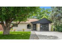 Charming ranch-style home with white brick, dark trim, and a well-manicured lawn at 1045 Locust St, Denver, CO 80220