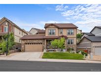 Inviting two-story home featuring stone accents, manicured lawn, and attached two car garage at 2575 Mccracken Ln, Castle Rock, CO 80104
