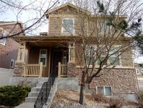 Charming two-story home featuring a welcoming porch and stone accents at 7354 Benton St, Arvada, CO 80003