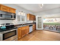 Bright kitchen features stainless steel appliances, wood cabinets and opens to a patio at 3629 Kalamath St, Denver, CO 80211