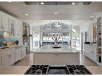 Bright and airy kitchen featuring a large island, stone accents, and scenic views at 5371 Hazel Rd, Evergreen, CO 80439