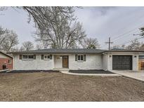 Charming single-story home featuring a white brick exterior, dark shutters, and a well-maintained front yard at 9455 W 37Th Ave, Wheat Ridge, CO 80033
