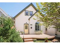Charming home featuring a quaint front porch, a yellow door, and well-maintained landscaping at 3110 N Franklin St, Denver, CO 80205