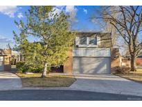 Charming two-story home featuring a brick facade and an attached two-car garage with landscaped yard and mature trees at 21 Birdie Ln, Littleton, CO 80123