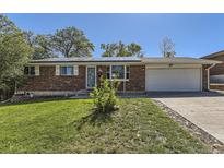 Charming brick home featuring solar panels and a well-manicured lawn, perfect for energy efficiency and curb appeal at 8258 Cherokee St, Denver, CO 80221