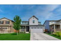 Charming two-story home with a well-manicured lawn, a two-car garage, and a welcoming front porch at 1066 S Eaton Park Ct, Aurora, CO 80018