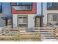 Charming townhouse exterior with a metal awning, decorative fencing and vibrant red accents at 5530 W 11Th Pl, Lakewood, CO 80214