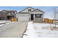 Charming home featuring a two-car garage, covered porch, and partial stone accents at 6501 14Th St, Frederick, CO 80530