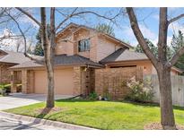 Charming home featuring a brick facade, two-car garage, and well-maintained lawn at 7500 E Dartmouth Ave # 8, Denver, CO 80231