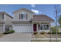 Charming two-story home featuring a white garage door, gray siding and a well-kept front yard at 18997 E 51St Pl, Denver, CO 80249
