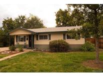 Charming single-story home with a well-maintained lawn and mature trees at 6213 Gray St, Arvada, CO 80003