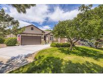 Charming home featuring a lush lawn, mature trees, and a spacious driveway leading to a two-car garage at 11070 Meade Ct, Westminster, CO 80031