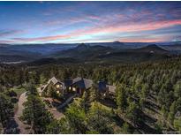 Expansive estate nestled among the trees, with scenic mountain views at sunset at 28800 Stonecrop Trl, Conifer, CO 80433