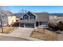 Charming two-story home featuring a three car garage, stone accents, and a welcoming front porch at 4695 Bobolink Dr, Castle Rock, CO 80109