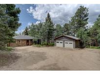 Charming home features stone accents and a two-car garage, nestled among mature trees for added privacy at 28858 Richmond Hill Rd, Conifer, CO 80433