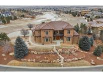 Expansive home featuring a landscaped front yard, stone accents, and a tile roof overlooking a nature preserve at 5261 Sedona Dr, Parker, CO 80134
