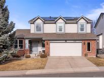 Charming two-story home featuring a two-car garage, solar panels, and a well-maintained front yard at 7292 Tenby Way, Castle Pines, CO 80108