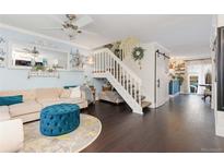 Inviting living room with elegant decor, modern lighting, and a staircase leading to the upper level at 9620 W Chatfield Ave # D, Littleton, CO 80128
