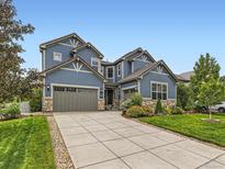 Beautiful two-story home featuring a manicured lawn, stone accents, and a spacious driveway leading to a two-car garage at 2896 Gemini Loop, Broomfield, CO 80023