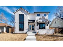 Elegant, two-story home features a white brick facade and a striking arched doorway at 1620 S Ogden St, Denver, CO 80210
