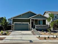 Charming home featuring a landscaped yard, covered porch, and attached two-car garage at 27580 E Cedar Pl, Aurora, CO 80018