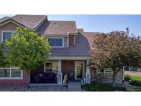 Charming townhome featuring a covered front porch, well-maintained landscaping, and a welcoming entrance at 10449 Paris St # 207, Commerce City, CO 80640